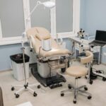 Phòng thủ thuật điều trị bệnh trĩ với ghế phụ khoa chuyên dụng, đèn soi và máy tính theo dõi.